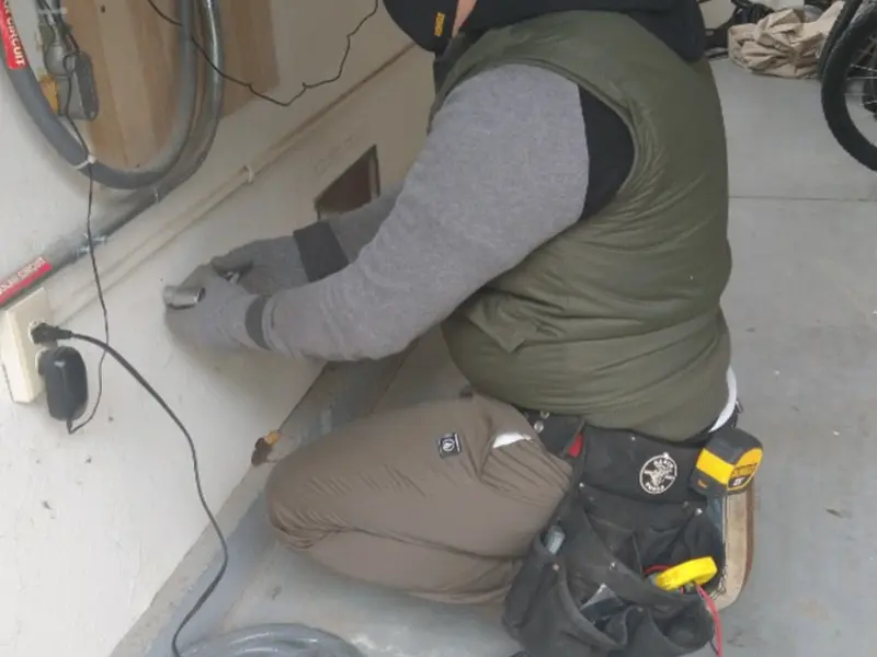 Electrician performing outlet wiring in a Metairie garage